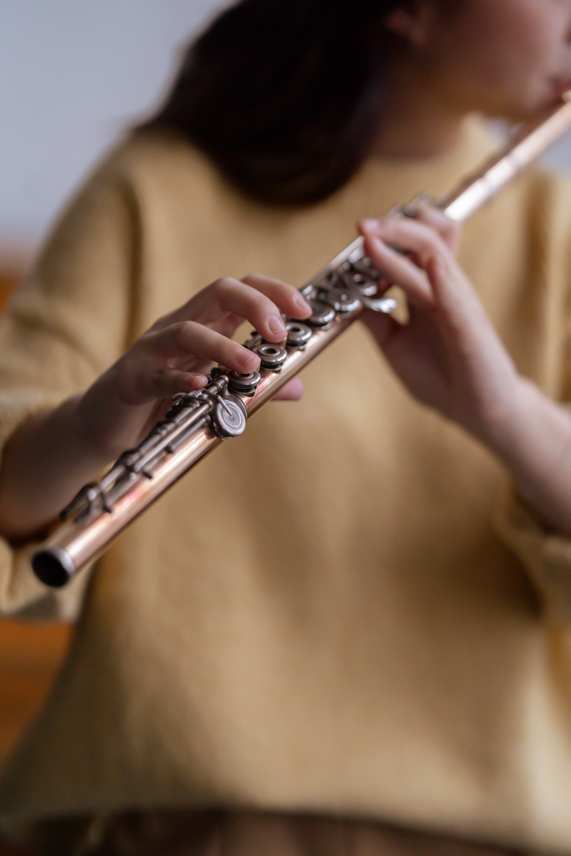 Female playing flute in daytime